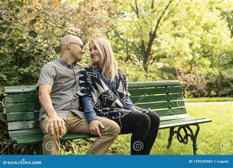 A Young Couple Sitting On Bench At The Park Stock Photo Image Of