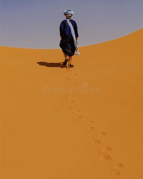 A Young Man Walking At The Desert Wearing Blue Robes Editorial Image