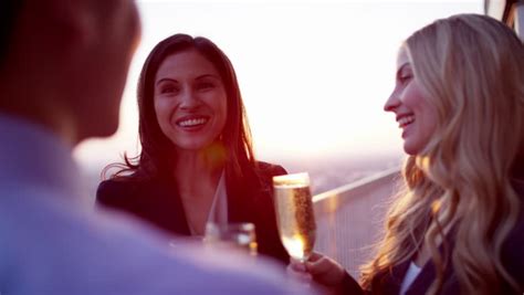 diverse smiling couple talking drinking at city cocktail roof party sun lens flare stock footage