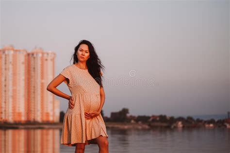 Pregnant Brunette Poses By Lake Young Asian Woman Holds Her Pregnant