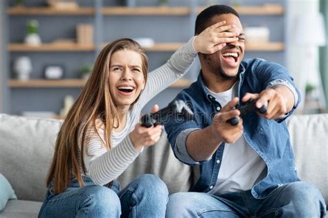 Cheerful Multicultural Couple Having Fun At Home Playing Video Games
