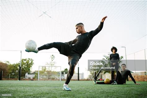 Player Kicking Soccer Ball On Field Stock Photo Download Image Now