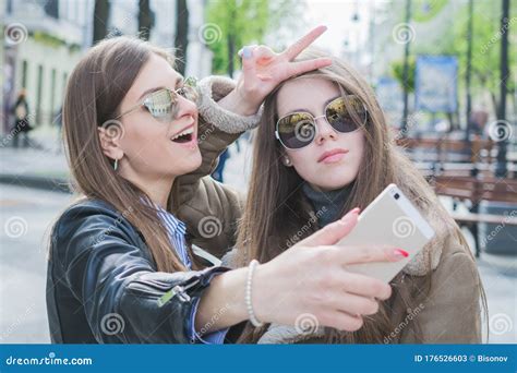 Two Beautiful Young Women Having Fun Making Photo And Grimacing With