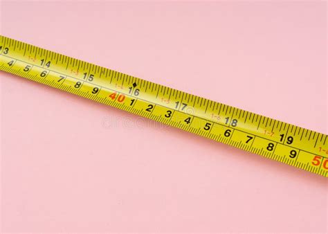 Measuring Tape With Centimeters And Inches On Pink Background Stock