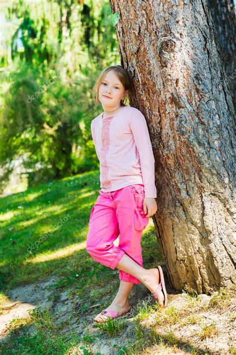 Outdoor Portrait Of A Cute Little Girl Of 7 Years Old Resting In A