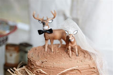 Two Deer Figurines On Top Of A Cake
