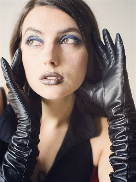 a woman wearing black gloves and blue eyes