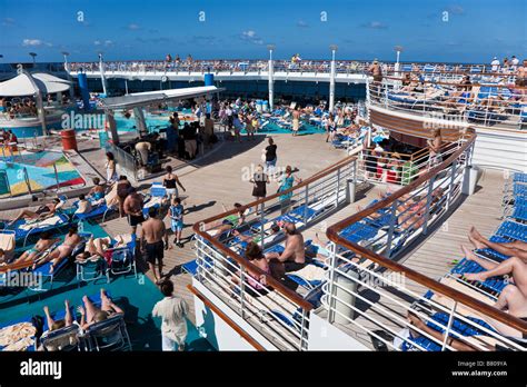 Cruise Ship Passengers Lounging On The Sun Deck Around The Pool On
