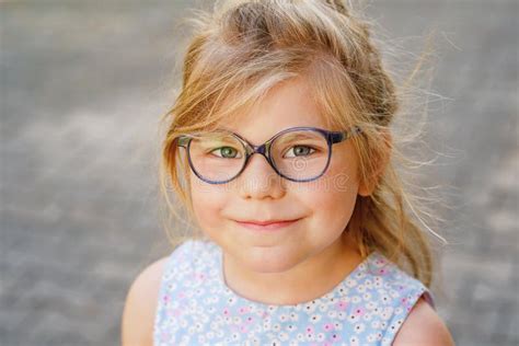 Portrait Of A Cute Preschool Girl With Eye Glasses Outdoors Happy