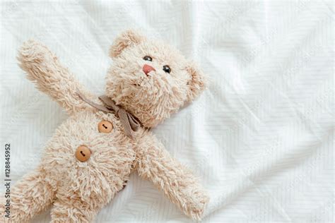 Teddy Bear Lying Down On The Bed Stock Photo Adobe Stock