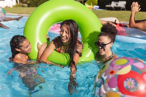 Diverse Group Of Friends Having Fun Playing On Inflatables In Swimming Pool Stock Image Image