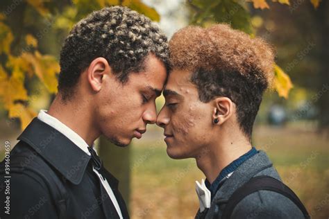 Handsome Young Gay Couple Standing Head To Head In Park During Autumn
