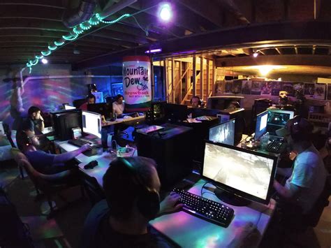 A Group Of People Sitting At Computers In A Room With Neon Lights On