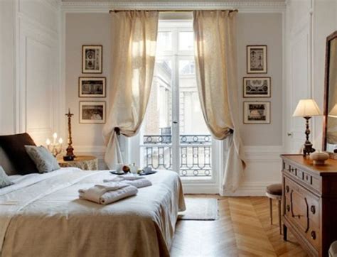 A Bed Room With A Neatly Made Bed Next To A Window And A Wooden Dresser