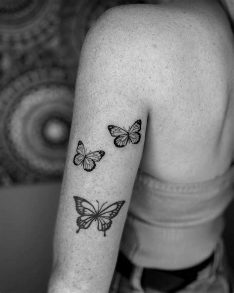 2 Butterflies In Fine Line Tattooed On The Upper Arm