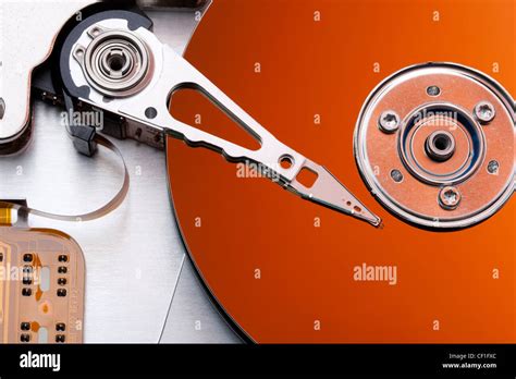 Platter And Head Of A Hard Disk Drive Reflecting An Orange Background