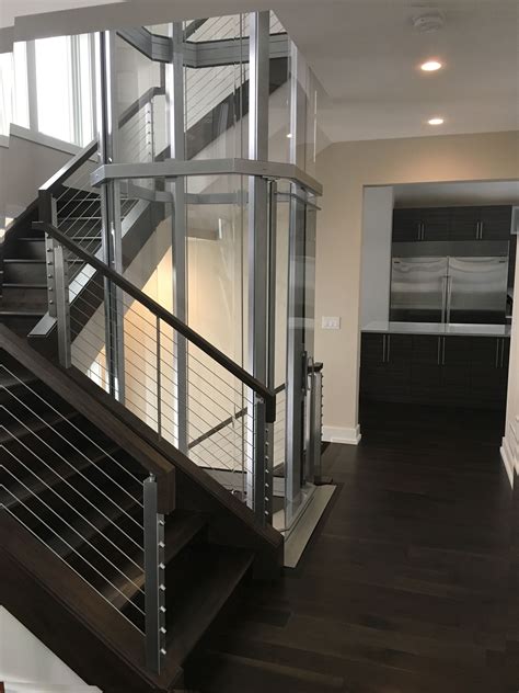 Modern Wrap Around Staircase With Silver Vuelift Octagonal Elevator
