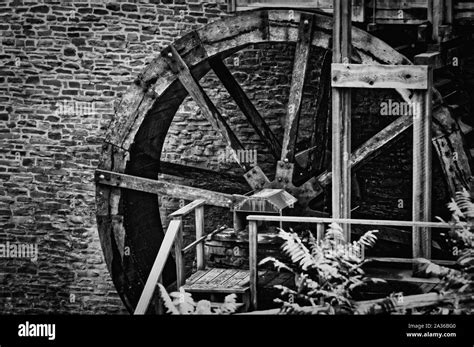 Old Water Mill Wheel In Front Of Stone Wall Black And White Stock