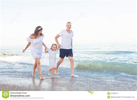 Parents Walk Along The Seashore With Daughter Stock Image Image Of
