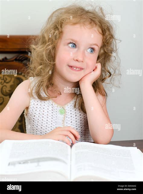 Cute Little Girl Sonriente Leyendo Un Libro Fotografía De Stock Alamy