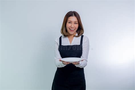 Asian Woman In Apron Holding Empty White Plate Or Dish Stock Image