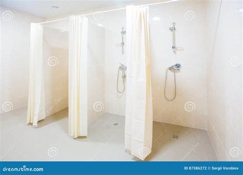 public shower room with several showers big light empty public shower room with bright walls