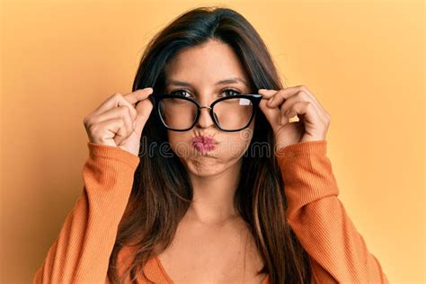 Beautiful Hispanic Woman Wearing Glasses Puffing Cheeks With Funny Face