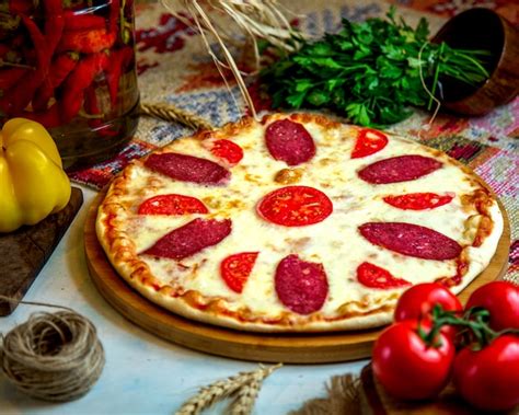 Pizza Au Pepperoni Avec Tranches De Tomate Et Fromage Photo Gratuite