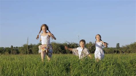 Three Happy Children Playing In The Field At The Day Time Stock