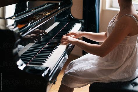 Woman In A White Dress Playing Piano Indoor By Stocksy Contributor
