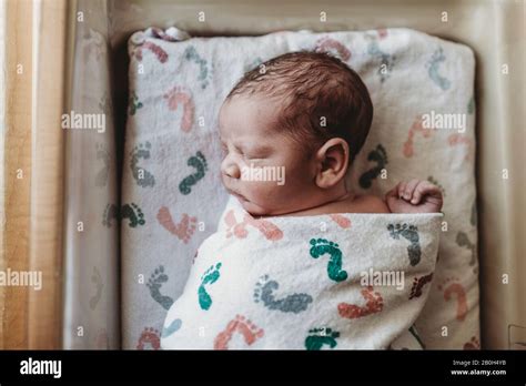 Overhead View Of Newborn Boy Swaddled In Hospital Bassinet Stock Photo