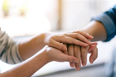 A Man And A Woman Holding Each Other Hands For Comfort Stock Image