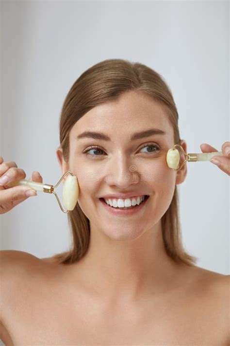 Beauty Face Care Young Woman Doing Face Massage With Jade Facial Rollers For Spa Skin Care