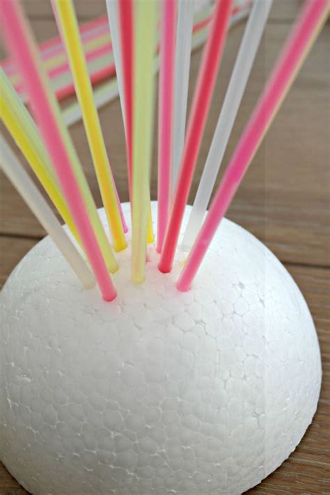 Several Colored Straws Sticking Out Of A White Vase