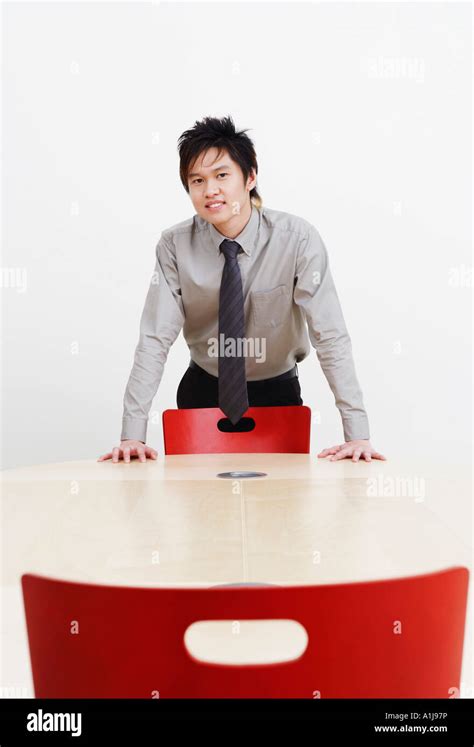 Portrait Of A Businessman Bending Forward Over A Conference Table And