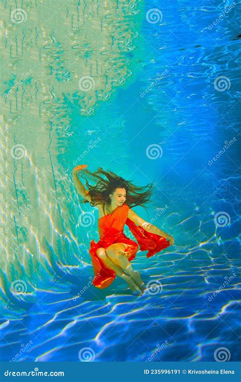 Girl In A Beautiful Dress Under Blue Water Female Model Posing Under