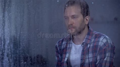 Sad Man Looking Through Window During Rainy Weather Thinking About