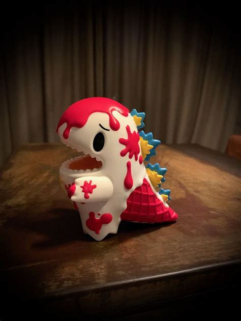 A Red And White Toy With Spikes On Its Head Sitting On A Table