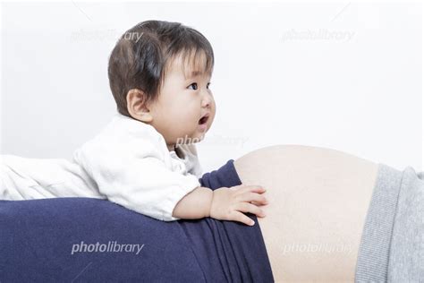 お母さんの妊娠した大きなお腹に乗る赤ちゃん 家族 妊娠 子供 赤ちゃん 年子イメージ 写真素材 5822975 フォトライブラリー Photolibrary