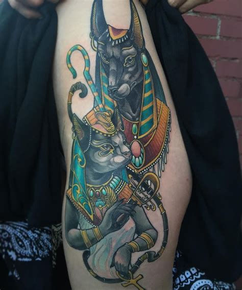 great time finishing this anubis and bastet tattoo on a hips thigh the 2 faces and lines are