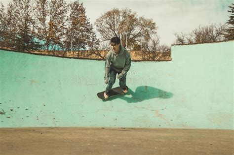 Guy Practicing Skateboarding And Doing Tricks In A Skatepark Stock