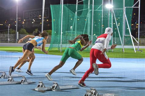 Female Track And Field Athletes Taking Off At Starting Block Stock