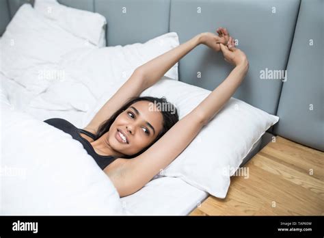 Young Woman Waking Up Stretching In Bed At Home Stock Photo Alamy