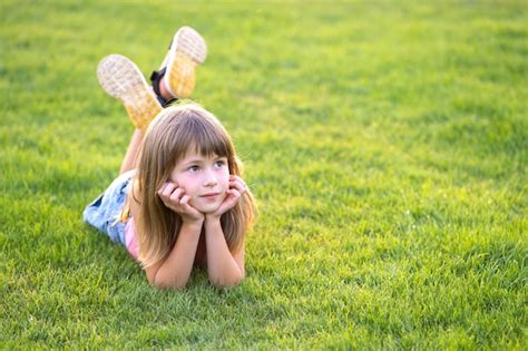 Premium Photo Young Pretty Child Girl Laying Down On Green Grass Lawn