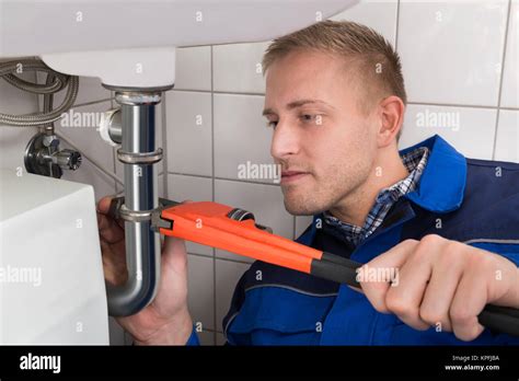 Male Plumber Fixing Sink In Kitchen Stock Photo Alamy
