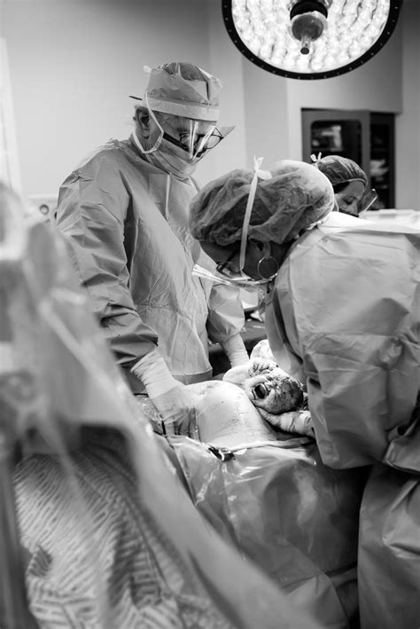 Two Doctors Performing Surgery On A Patient In An Operating Room At The