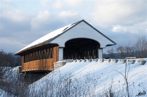 Snow Covered Wooden Covered Bridge Illuminated By Late Afternoon Axis