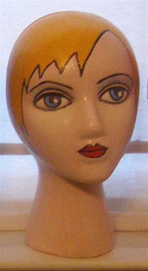A Mannequins Head With Yellow Hair And Blue Eyes Is Shown In Front Of