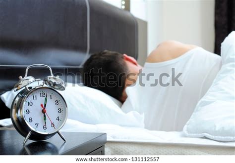 Man Sleeping Alarm Clock Foreground Stock Photo Edit Now 131112557