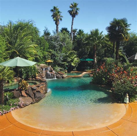 Residential Beach Entry Tropical Pool With Rock Waterfalls And Palm